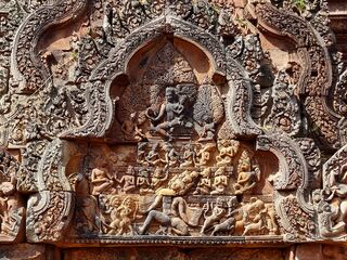 A carved triangular pediment crowded with figures around a many-armed central figure.