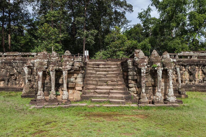 A long stone terrace with a central stairway; carved elephant heads and trunks form pillars on each side, with a lawn in front.