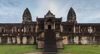 A steep stone stairway climbing to the central gallery of Angkor Wat, flanked by two towers.