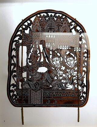 A cut-leather panel with three figures beneath a carved roof, set on wooden poles.