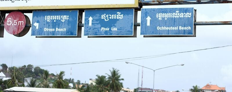 Road signs naming Otres Beach, Phsa Leu and Ochheuteal Beach in Khmer script and in English letters.