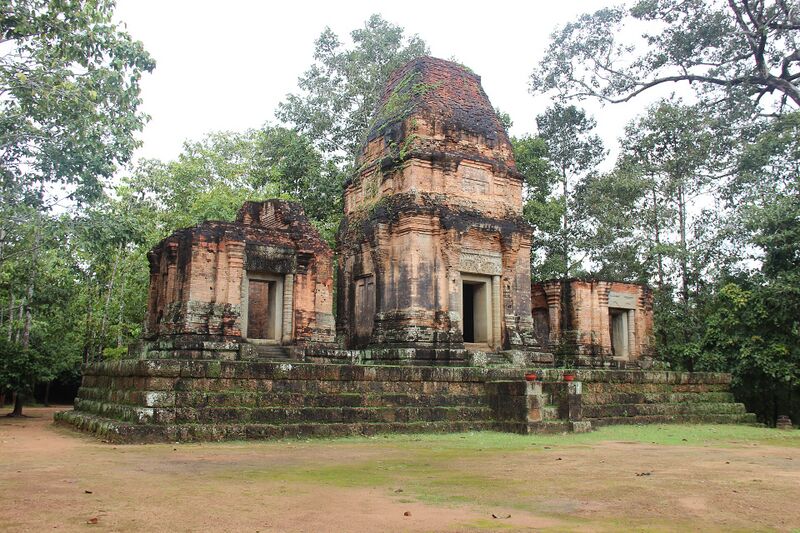 Three brick sanctuary towers on a low platform among trees.